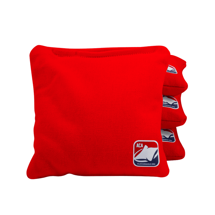 Regulation cornhole bag beside a ruler and scale with eight bags arranged for a complete game